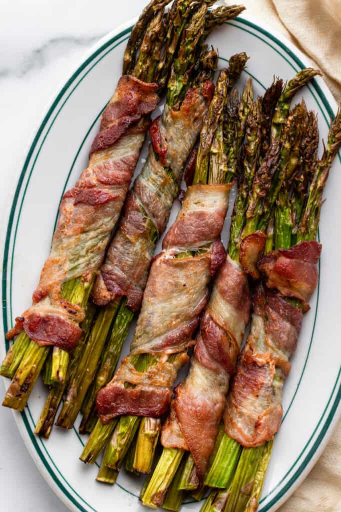 Air Fryer Bacon Wrapped Asparagus arranged on a dinner plate