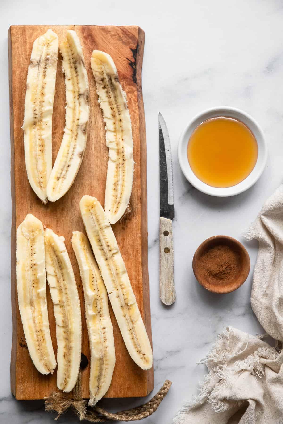 slices of banana on a cutting board with honey