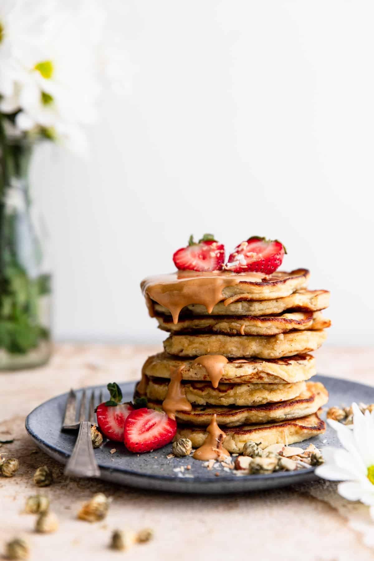 Whole30 Banana Pancakes with strawberries and drizzle on top